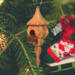 Handcrafted miniature wooden birdhouse ornament shaped like an icecicle with a pointed roof and base, featuring a rounded entrance hole and a perched bird, and made from reclaimed hardwoods finished with a satin shellac.