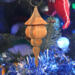 Handcrafted miniature wooden birdhouse ornament shaped like an icecicle with a pointed roof and base, featuring a rounded entrance hole and a perched bird, and made from reclaimed hardwoods finished with a satin shellac.