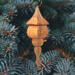 Handcrafted miniature wooden birdhouse ornament shaped like an icecicle with a pointed roof and base, featuring a rounded entrance hole and a perched bird, and made from reclaimed hardwoods finished with a satin shellac.