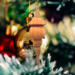 Handcrafted miniature wooden birdhouse ornament shaped like an icecicle with a pointed roof and base, featuring a rounded entrance hole and a perched bird, and made from reclaimed hardwoods finished with a satin shellac.