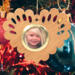 Wooden heart-shaped ornament with scalloped edges and an oak grain finish, featuring a removable round gold frame that holds a photo of a smiling blonde child.