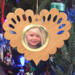 Wooden heart-shaped ornament with scalloped edges and an oak grain finish, featuring a removable round gold frame that holds a photo of a smiling blonde child.