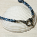 A closeup of toggle clasp and Czech crystals placed on a white seashell