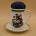 This is a front view of the pincushion attached to the saucer. It clearly shows the vibrancy of the bouquet of pansies. This is a front view of the pincushion attached to the saucer. It clearly shows the vibrancy of the bouquet of pansies.