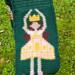 A close up of the ballerina pocket. She's wearing a pink dress with yellow details, and has brown hair, pale skin, and a yellow crown. A close up of the ballerina pocket. She's wearing a pink dress with yellow details, and has brown hair, pale skin, and a yellow crown.