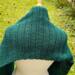 A close up of the scarf draped over the shoulders of the dress form. There is green grass in the background. A close up of the scarf draped over the shoulders of the dress form. There is green grass in the background.