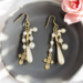 long dangle cross and pearl earrings.