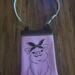 Pink vinyl crossbody bag with embroidered pig design wearing a floral bandana. White zipper top and strap