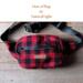 Red and black buffalo plaid wool hunting belt bag handcrafted from Johnson Woolen Mills fabric lays in natural light - ideal for hunters. Red and black buffalo plaid wool hunting belt bag handcrafted from Johnson Woolen Mills fabric lays in natural light - ideal for hunters.