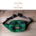 Green and black buffalo plaid wool hunting belt bag handcrafted from Johnson Woolen Mills fabric lays in natural light - ideal for hunters. Green and black buffalo plaid wool hunting belt bag handcrafted from Johnson Woolen Mills fabric lays in natural light - ideal for hunters.