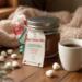 Handmade Hot Cocoa Jar beside marshmallows and cup of cocoa, cozy Christmas drink mix gift by Me and You Creations.