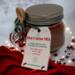 Christmas Hot Cocoa Jar on red cloth with lights and stars, cozy handmade cocoa gift for the holidays.