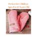 A pair of handmade kids ages 8 to 10 sized mittens made from a soft upcycled coral pink Eddie Bauer fleece jacket, with a faux leather tag.
