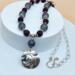 Pewter pendant  embossed with a vine pattern on necklace with druzy agate, blue patterned glass beads, a steel chain, and silver hook clasp.