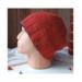 Profile image of slouchy rust wool knit hat with navy trim and small leather tag, styled on mannequin head.