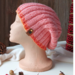 A hand knit pink wool beanie with a ribbing stretchy stitch pattern. For children and preteens ages 10, 11, 12, 13, 14.