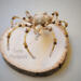 Handmade wire spider ornament in gold, cream, and honey-toned beads on a neutral background