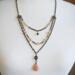 Handmade three-strand antiqued brass necklace with peach crystals, glazed agate beads, and a peach moonstone teardrop pendant.