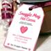 Close-up of Snuggle Mug handmade hot cocoa gift tag showing heart design and mixing instructions on glass jar