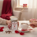 Love You a Latte hot cocoa jar being shared beside a steaming cup, Valentine gift moment with rose petals, cozy handmade cocoa