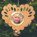 Wooden heart-shaped ornament with scalloped edges and an oak grain finish, featuring a removable round gold frame that holds a photo of a smiling blonde child.