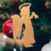 A handmade wooden Christmas ornament in the shape of a cheerful angel, featuring a halo, wings, and a raised arm ringing a bell, hand-cut from solid hardwood and finished with clear shellac.