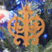 Intricate Victorian-style fretwork Christmas tree ornament handcrafted from natural hardwood with visible wood grain, showcasing symmetrical curls, loops, and ornate cut-out designs.