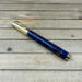 Gold rollerball pen with blue resin and pinecones 