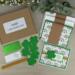 A St. Patty's Day card making kit with clovers, gold ribbons, stamped sentiments and glitter mats to make 6 greeting cards.