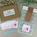 An Easter card making kit with plaid scrapbook paper, pink bunny embellishments, and blue ribbons to make 6 greeting cards.