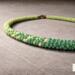 Macro detail of Verdant Fade Kumihimo Necklace beads, showing tight hand-braided Kumihimo texture and green color shift