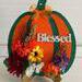 Complete view of pumpkin on a wood picture easel for decoratibe placement.