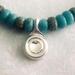 Up close picture of the silver pendant and the balance with sizing of turquoise beads.