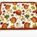 Front of hot pad.  Pumpkins and leaves on white background.