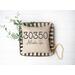 zip code pillow with gray font on tobacco basket