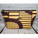 Front of a golden yellow and brown abstract African print large makeup bag featuring a gunmetal zipper and metal Bass Creations logo.